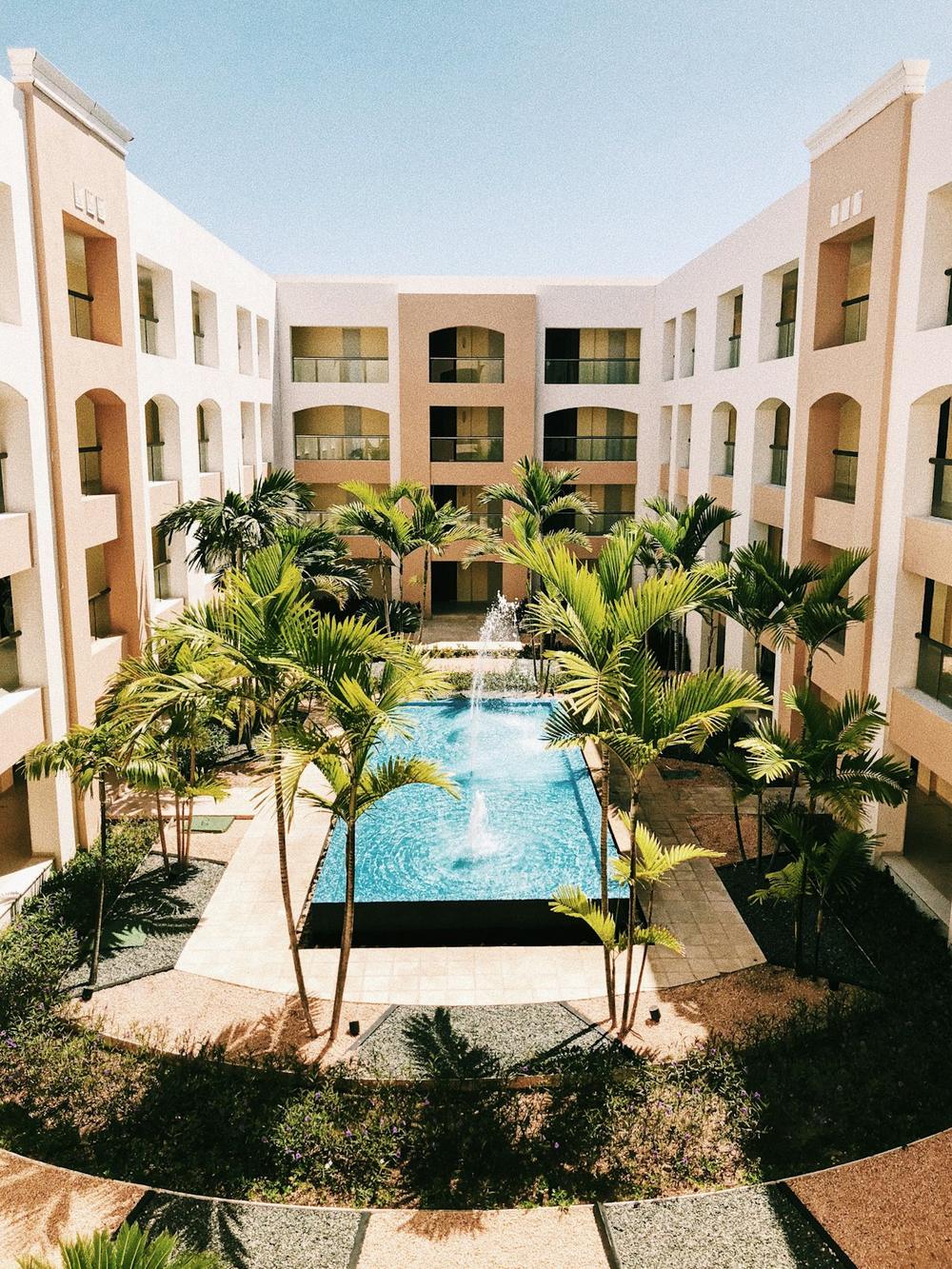 Cortile interno di un hotel con piscina e palme